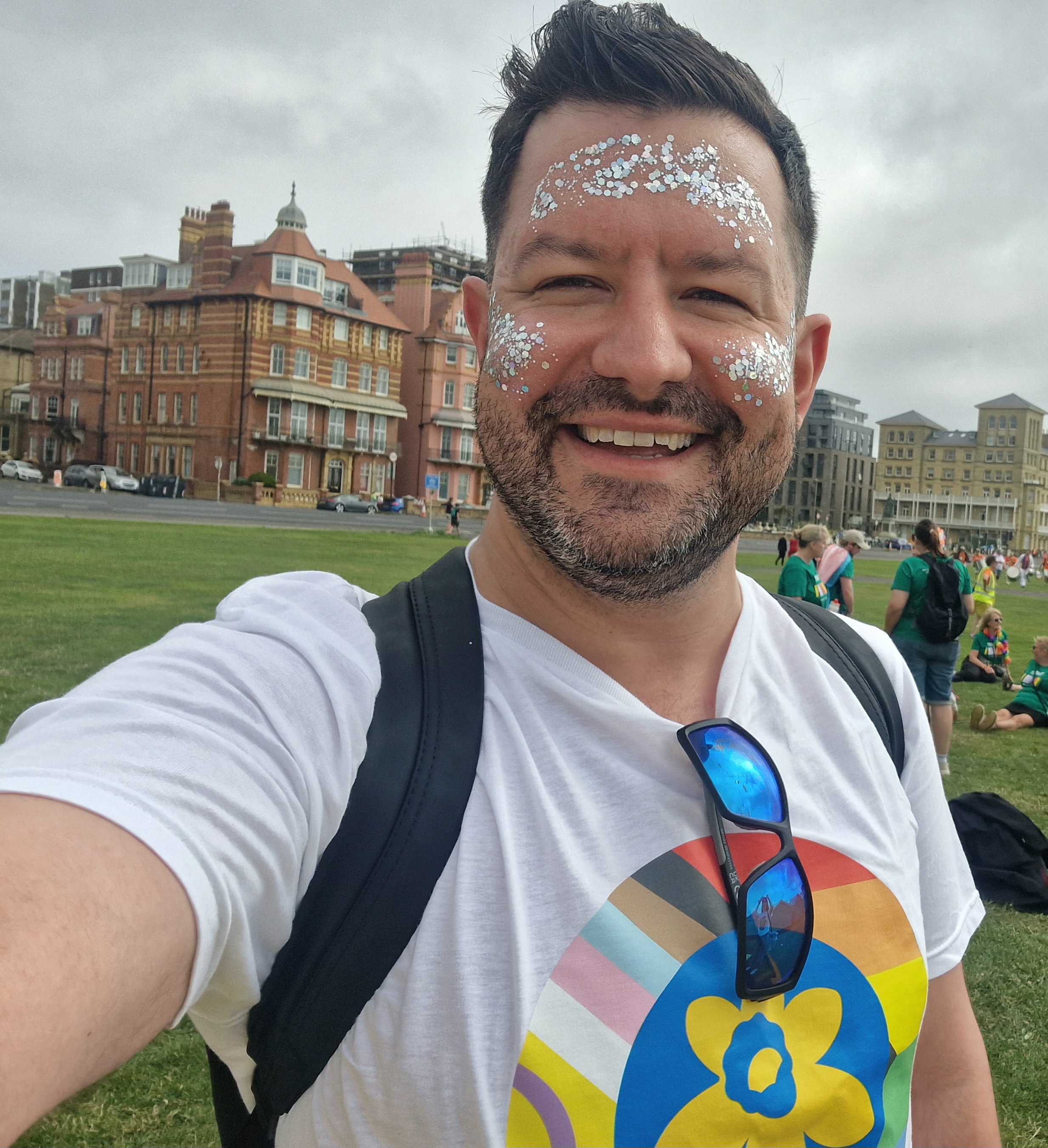 A photo of a person with glitter on their face and a Pride t-shirt.