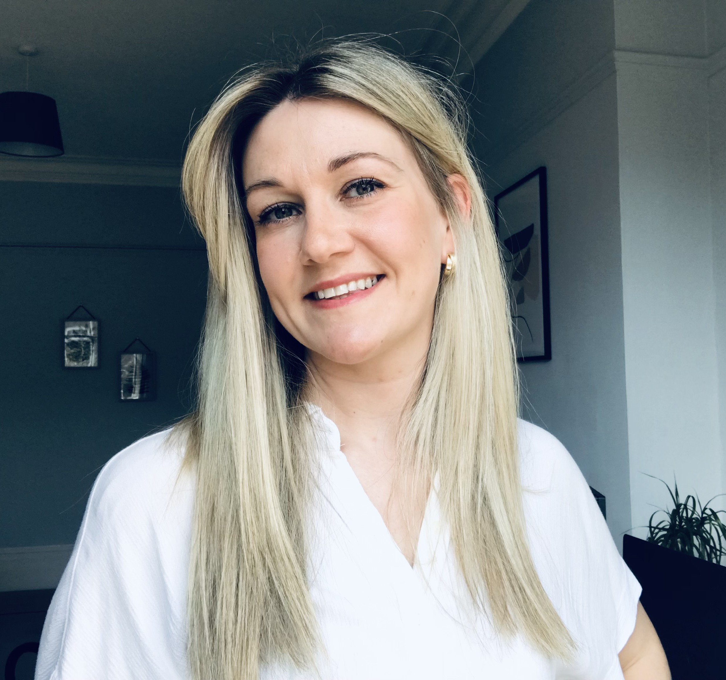 Photo of a woman smiling at the camera indoors.