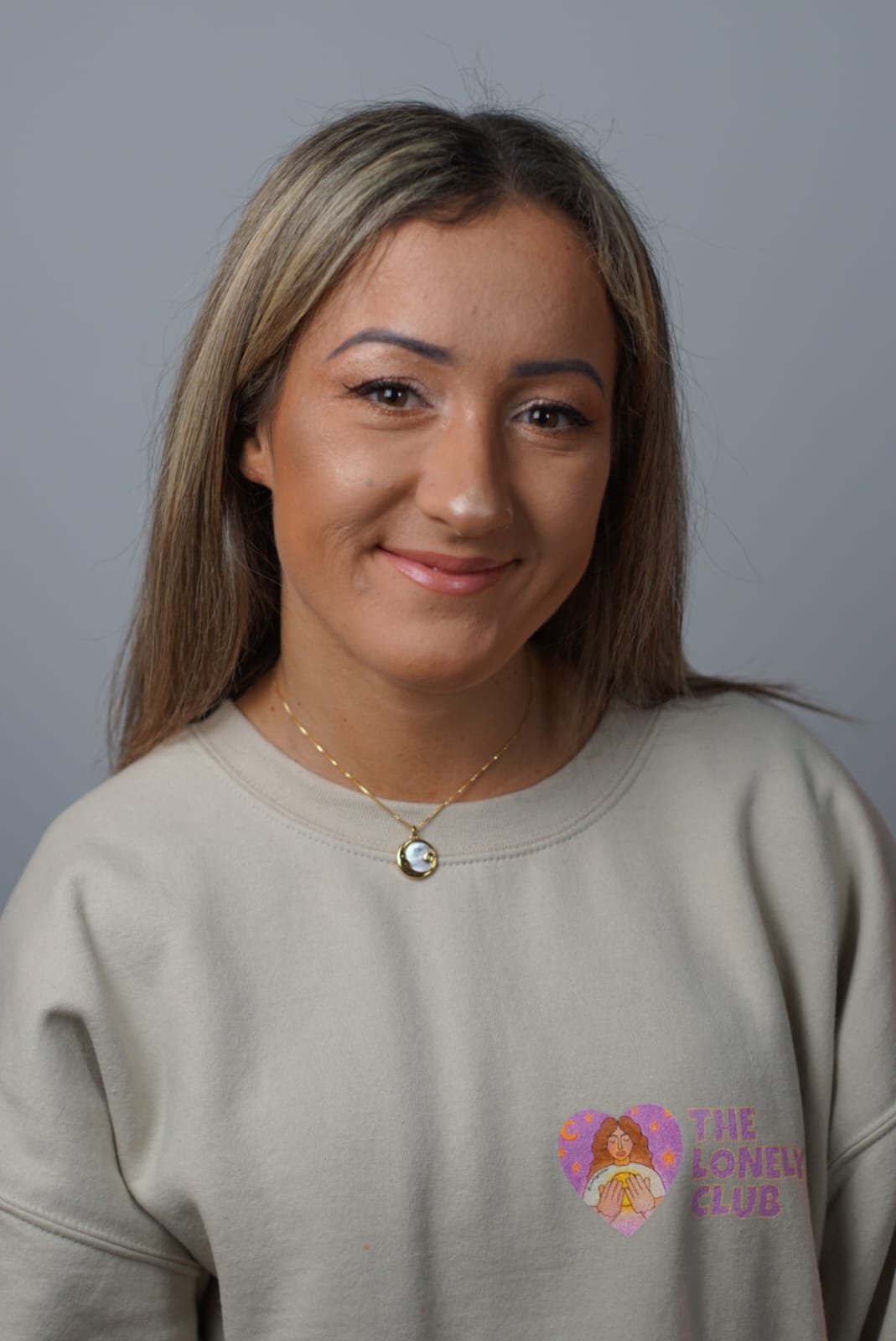 A woman against a grey backdrop.