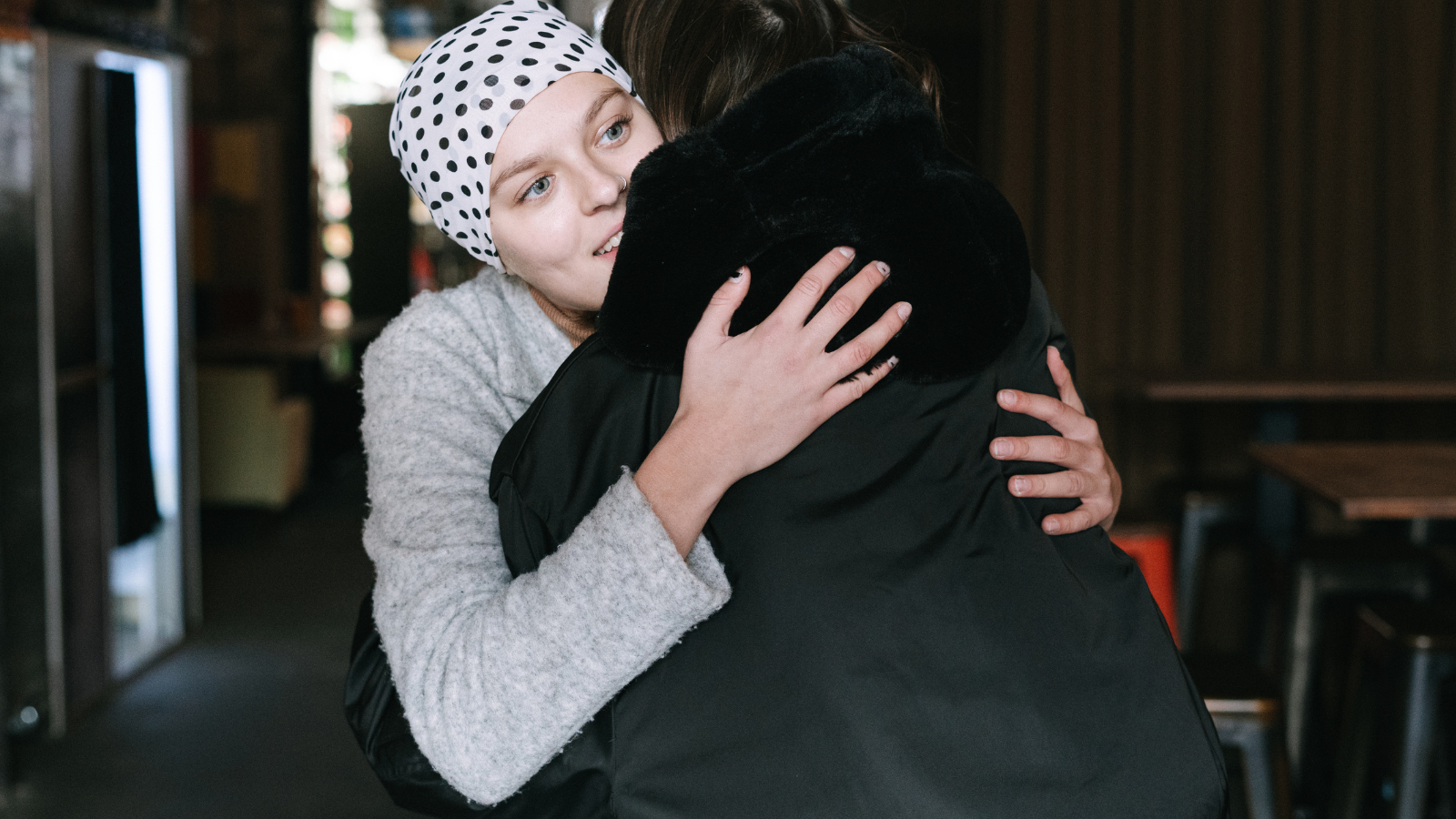 Two people hugging indoors