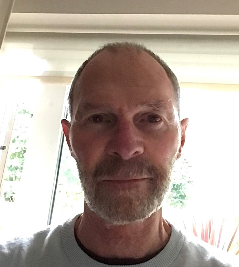A man with a window behind him.