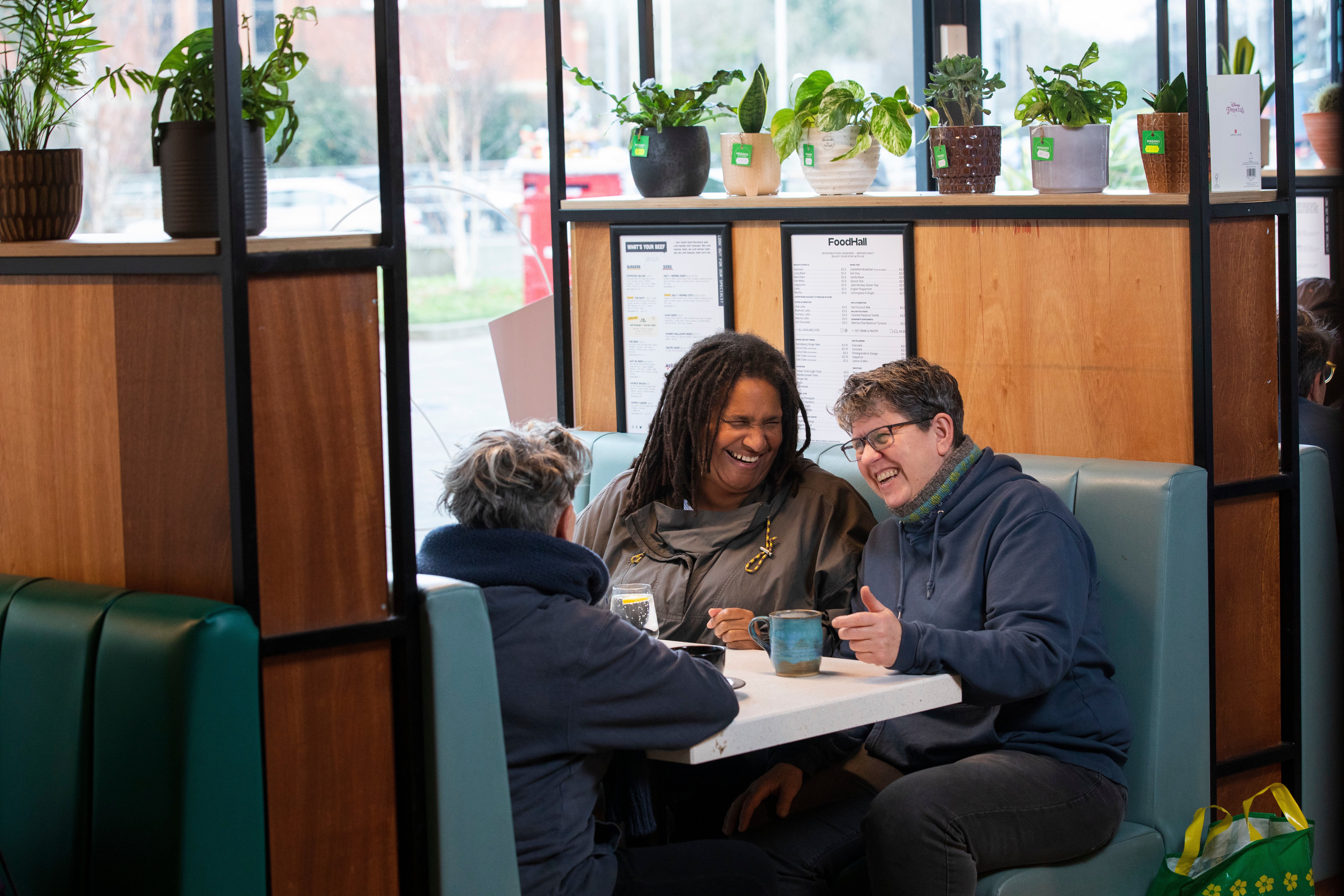 Three women socialising in a café. 