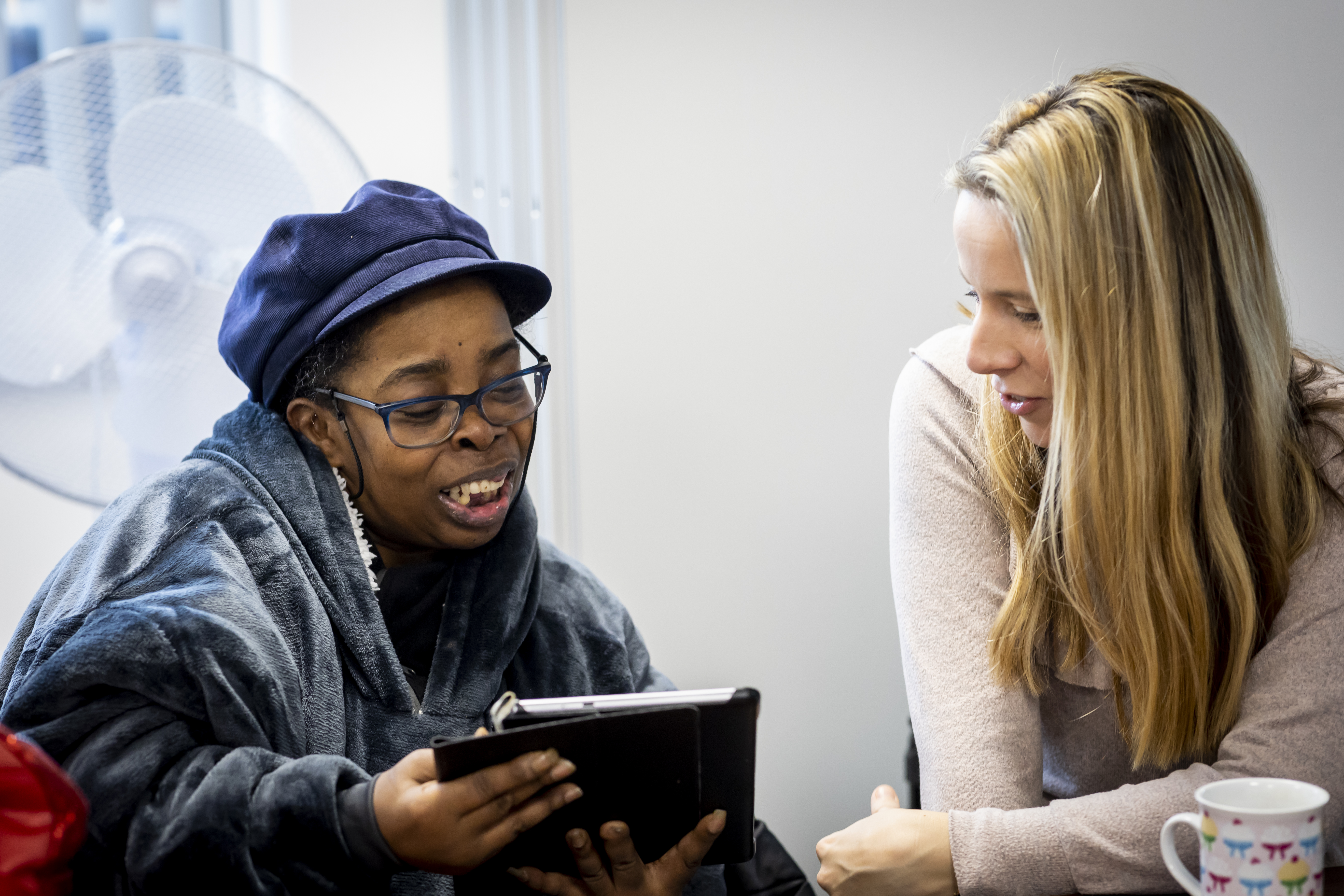 Two women looking at an iPad together.