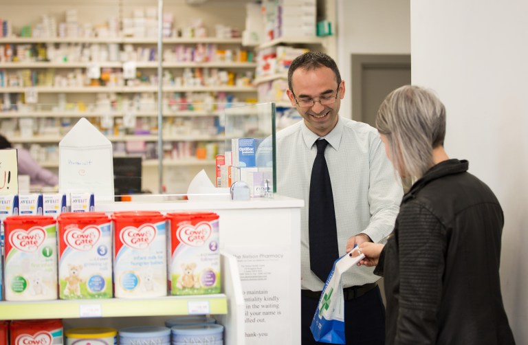 Male pharmacist serving a female customer