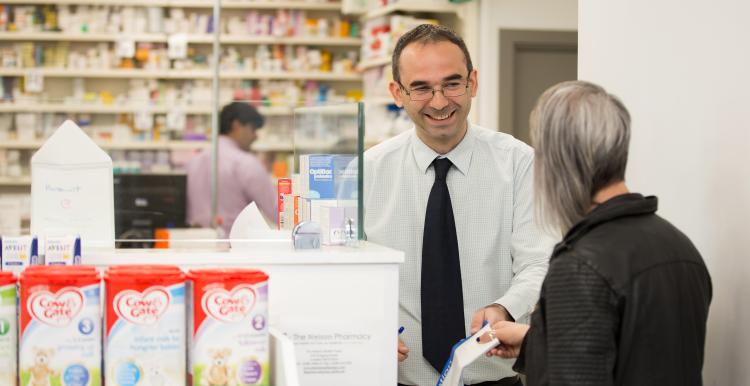 Pharmacist assisting customer.