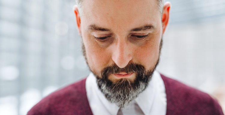 a bearded man, sad, looking down