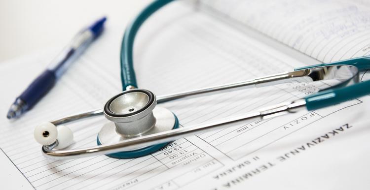 A pen and stethoscope on top of documents