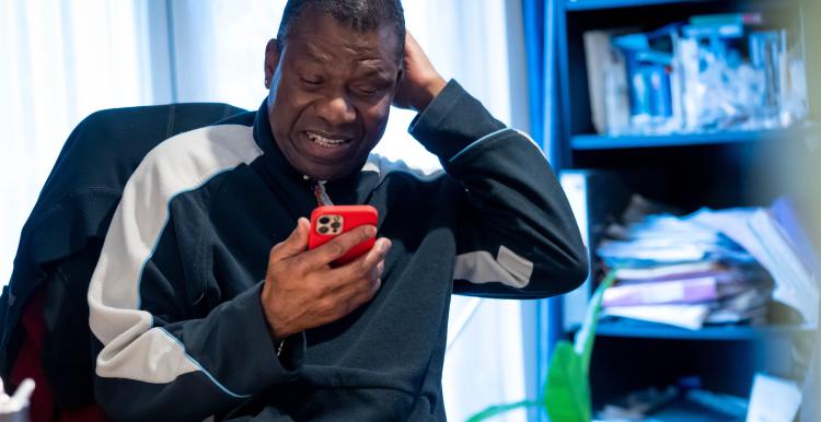 Man using his phone in an indoor setting.