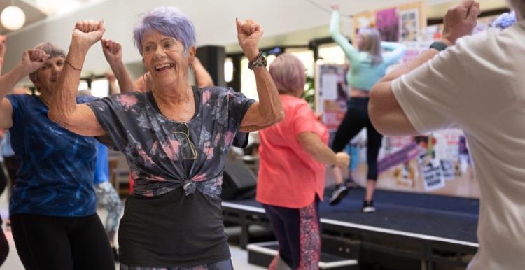 Older adults smiling while taking part in an exercise class