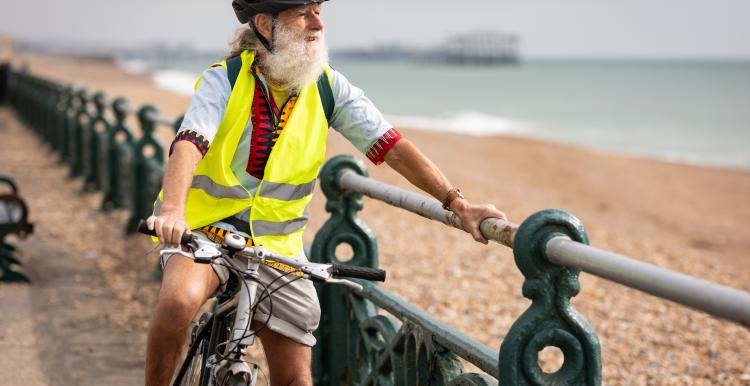 Older adult riding a bike along the Brighton seafront.