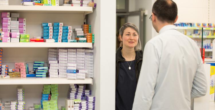 A service user speaking to a pharmacist in a pharmacy.