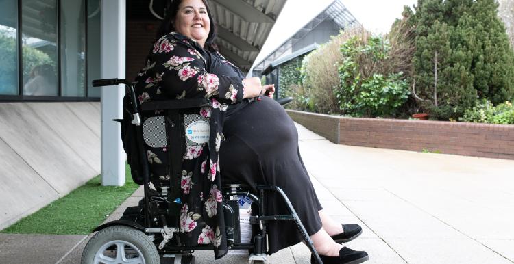 A woman in a wheelchair outside.