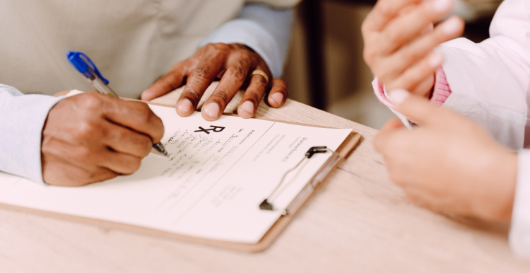 Someone filling out a form next to another person. This is a close-up shot of two sets of hands.
