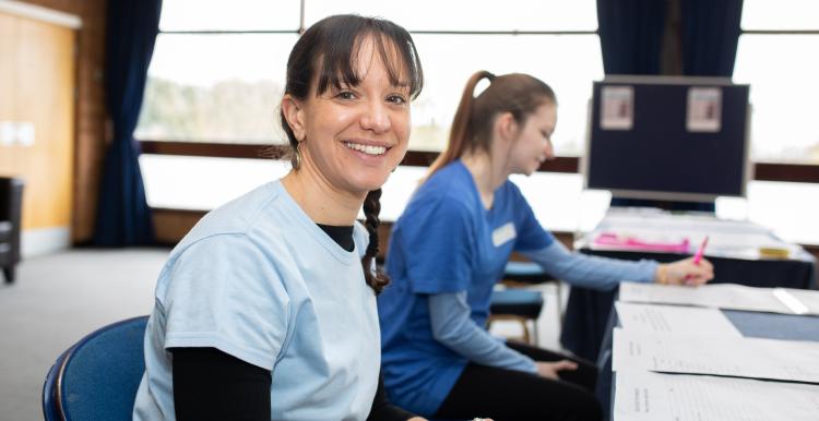 A healthcare professional smiling while sat at a desk.