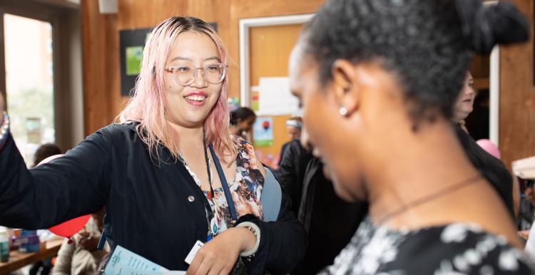 Two women talking in a busy event environment