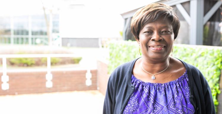 A woman smiling in an outdoor setting.