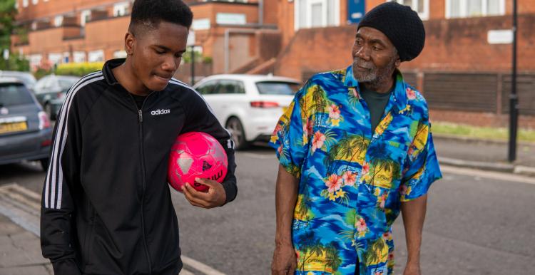 Older man and young man walking together.