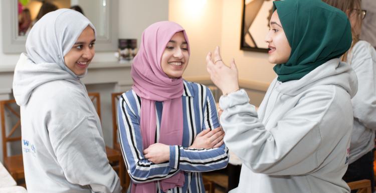 Three young women talking.