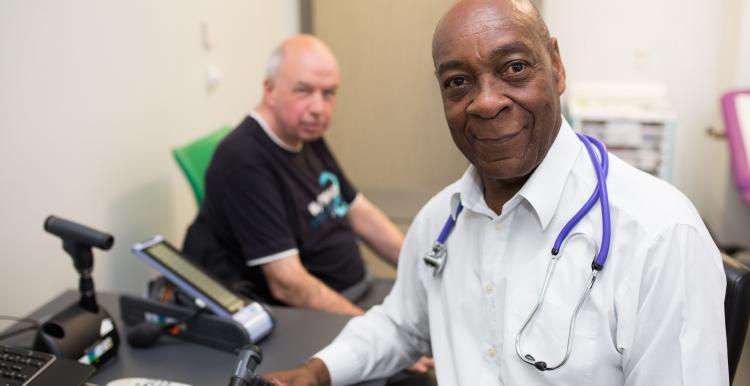 A GP and patient in a GP office.