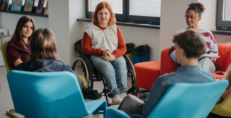 Young people sat together in chairs and a wheelchair