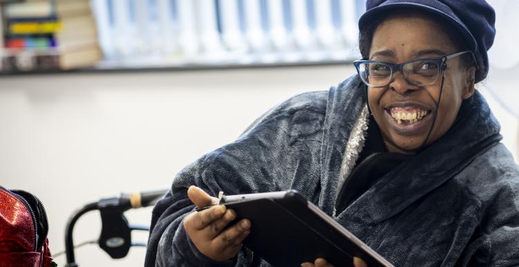 Woman smiling while holding an iPad