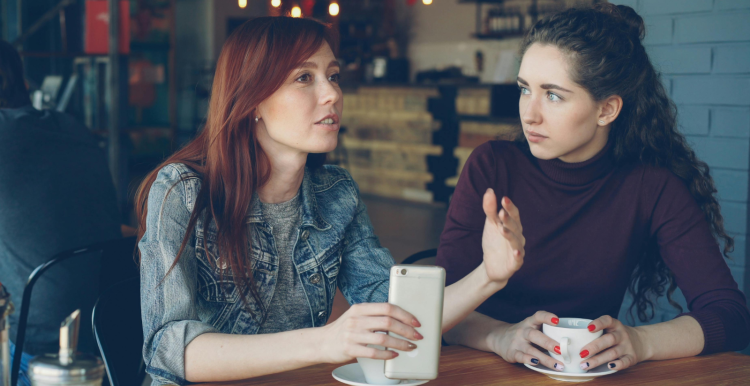 Two young women talking in a café