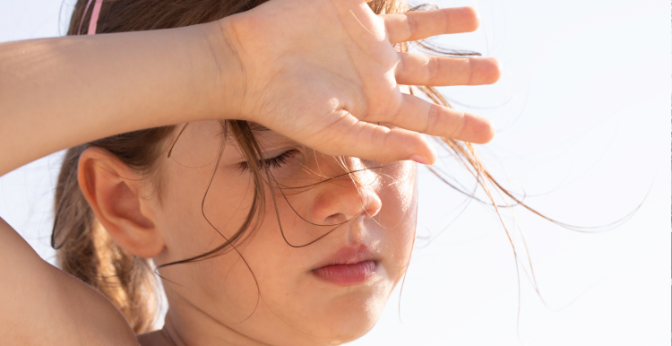 Child shielding their eyes in hot weather
