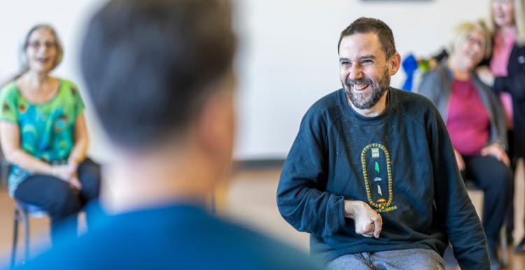 Several people sat smiling in an indoor setting.
