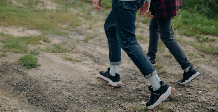 Two people walking outside, with a close-up shot of their legs walking in sync.