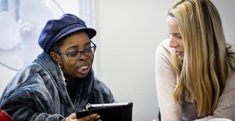 Two women looking at an iPad together.