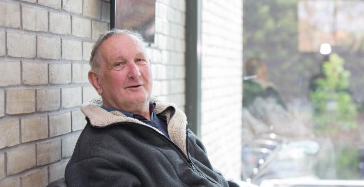 An older man sat down in a waiting area.