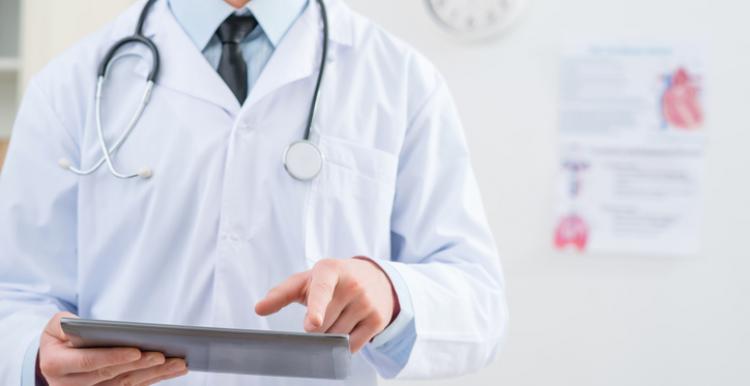 Doctor in white coat holding iPad, Left side of shot, Shoulder/Torso view