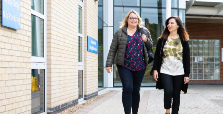 Two women walking near a hospital