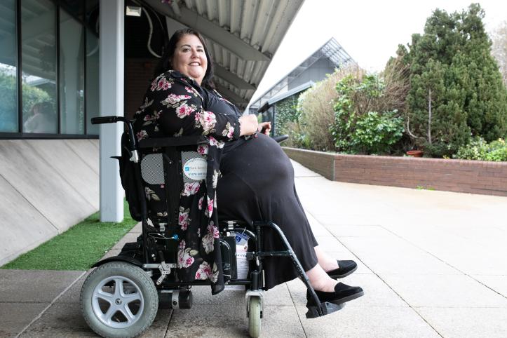 A woman in a wheelchair outside.
