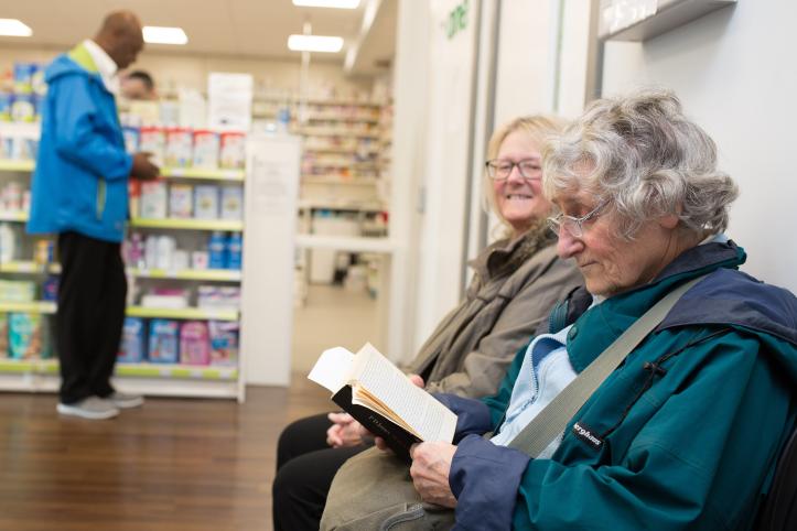 Three people waiting at a pharmacy.