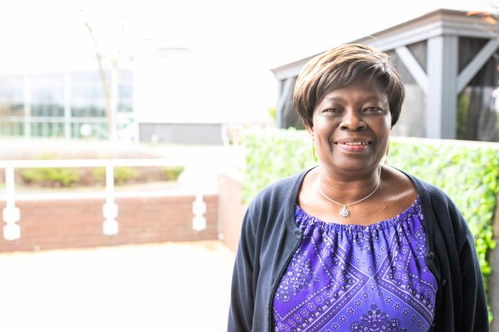 A woman smiling in an outdoor setting.