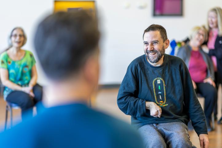 Several people sat smiling in an indoor setting.