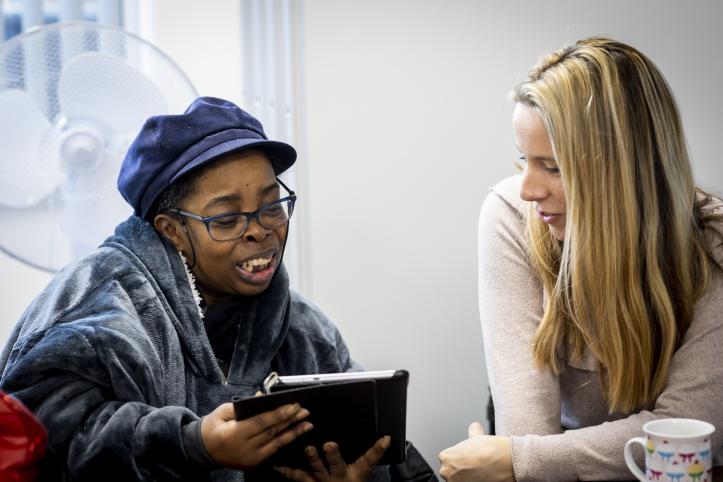 Two women looking at an iPad together.