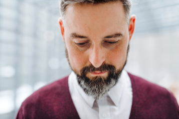 a bearded man, sad, looking down