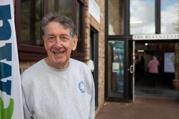 Man smiling outside building.