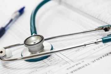 A pen and stethoscope on top of documents