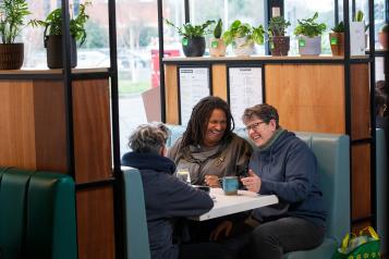 Three women socialising in a café.