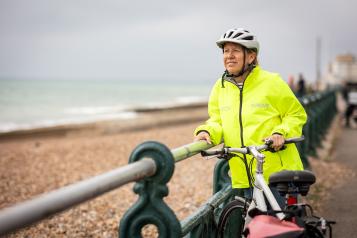 Woman and her bike by the Brighton shoreline.