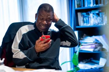 Man using his phone in an indoor setting.