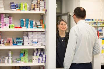 A service user speaking to a pharmacist in a pharmacy.