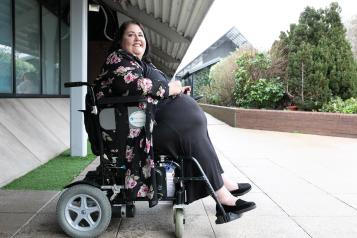 A woman in a wheelchair outside.