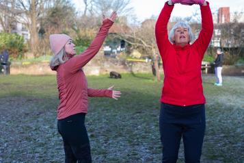 Two women exercising outside during winter.