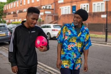 Older man and young man walking together.