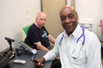 A GP and patient in a GP office.