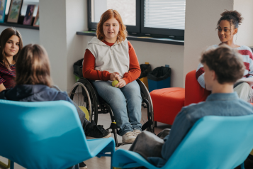 Young people sat together in chairs and a wheelchair
